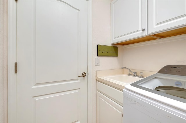 washroom featuring washer / clothes dryer, sink, and cabinets