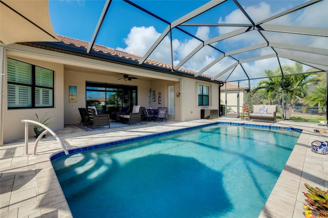 view of swimming pool featuring outdoor lounge area, glass enclosure, ceiling fan, and a patio area