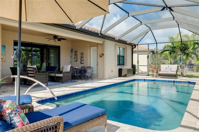 view of swimming pool featuring a lanai, a patio area, and ceiling fan