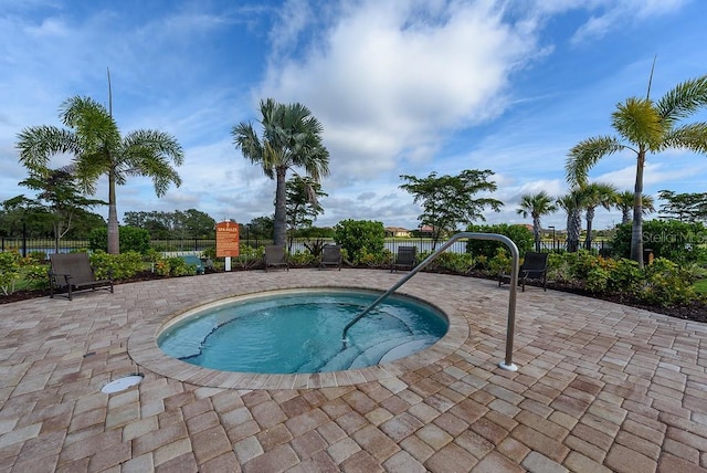 view of swimming pool with a hot tub