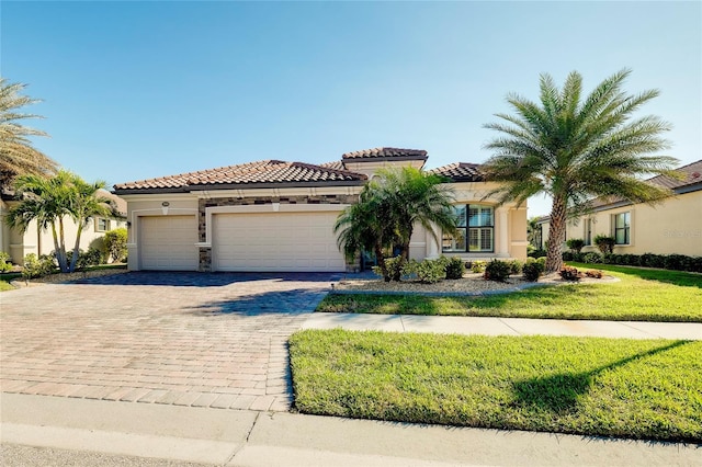 mediterranean / spanish-style home featuring a garage and a front yard