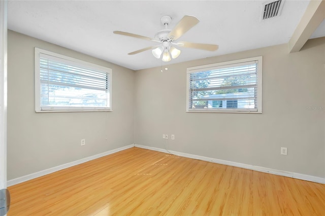 empty room featuring ceiling fan, light hardwood / wood-style floors, and a healthy amount of sunlight