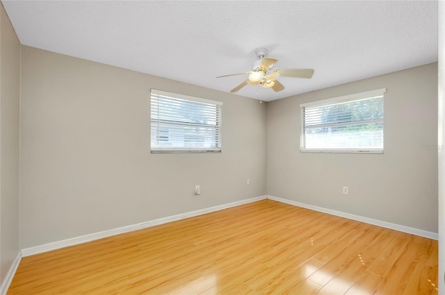 spare room with ceiling fan, a textured ceiling, and light wood-type flooring