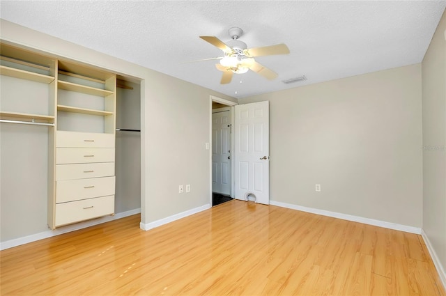 unfurnished bedroom featuring ceiling fan, a closet, hardwood / wood-style floors, and a textured ceiling