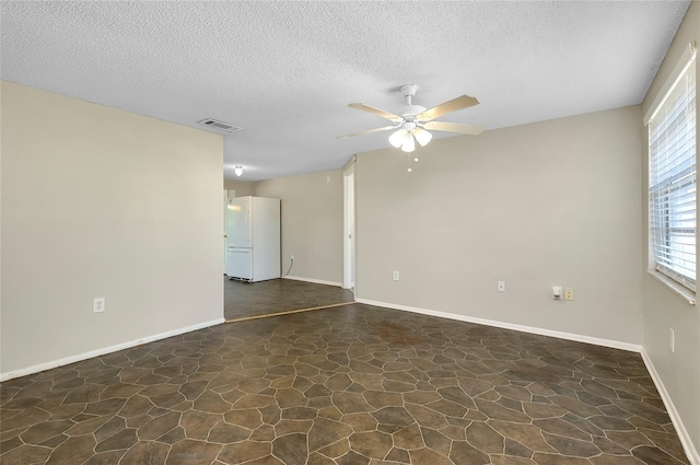 unfurnished room with ceiling fan and a textured ceiling