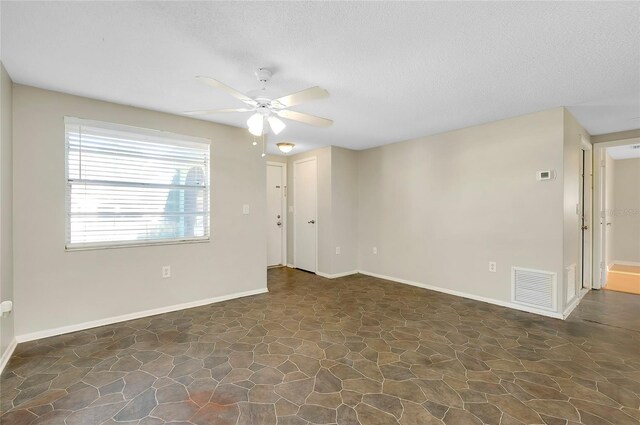 spare room featuring ceiling fan and a textured ceiling