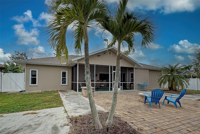 back of property featuring a yard, a patio, and a sunroom