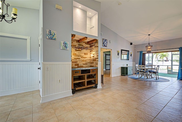 unfurnished dining area featuring light tile patterned floors, high vaulted ceiling, and an inviting chandelier