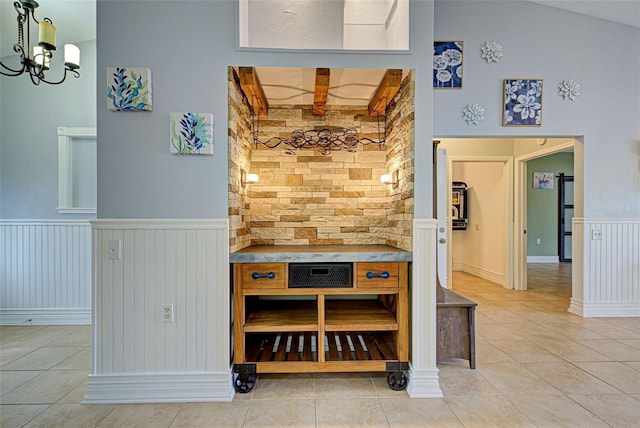 interior space with tile patterned flooring, high vaulted ceiling, and a chandelier