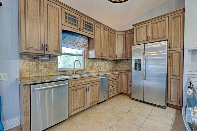 kitchen with light stone counters, sink, appliances with stainless steel finishes, and tasteful backsplash