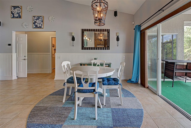 dining space featuring light tile patterned floors, high vaulted ceiling, and a chandelier