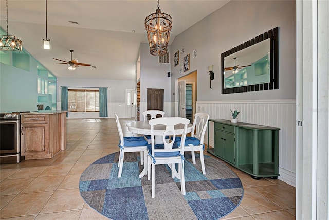 tiled dining area with high vaulted ceiling and an inviting chandelier