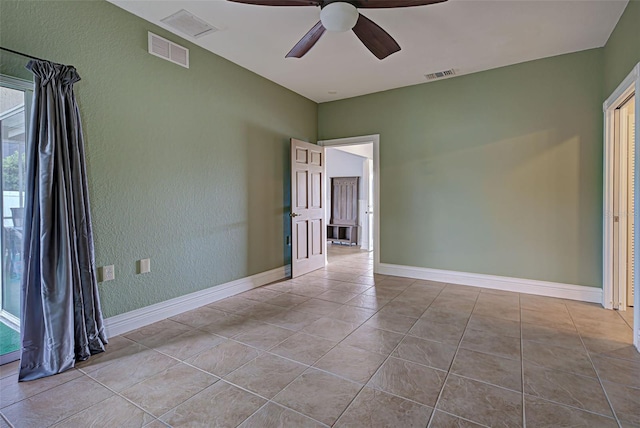 tiled spare room with ceiling fan