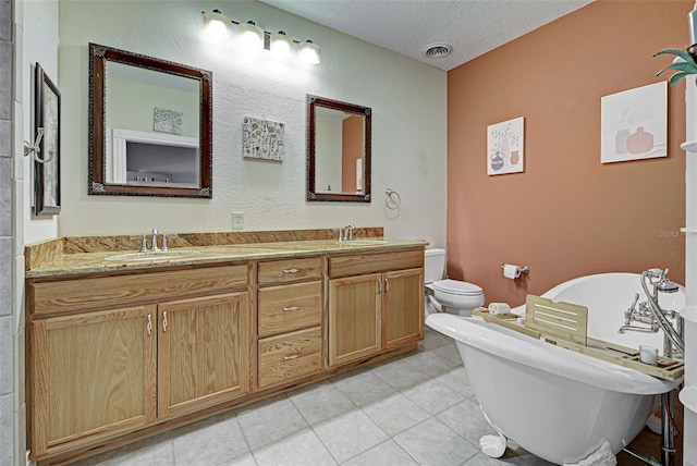 bathroom featuring a washtub, a textured ceiling, tile patterned floors, and toilet