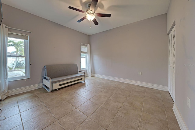 unfurnished room with ceiling fan and light tile patterned flooring