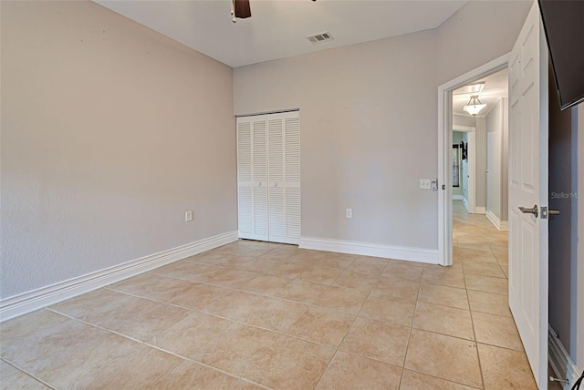 unfurnished bedroom with ceiling fan, a closet, and light tile patterned floors