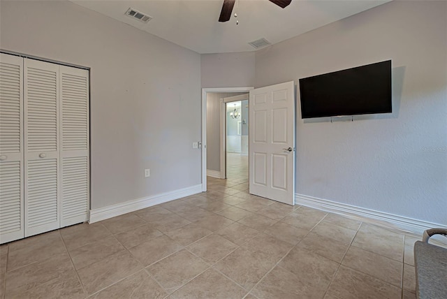 unfurnished bedroom with ceiling fan, light tile patterned flooring, and a closet