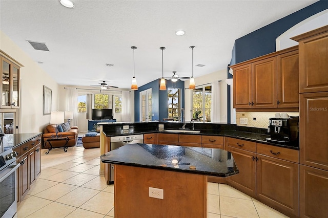 kitchen with sink, ceiling fan, light tile patterned floors, appliances with stainless steel finishes, and a kitchen island