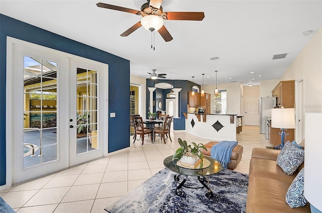 living room with ceiling fan, a healthy amount of sunlight, light tile patterned floors, and french doors