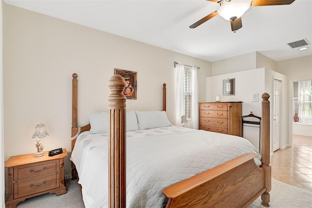 tiled bedroom featuring ceiling fan and a closet