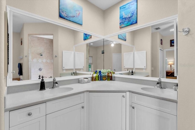 bathroom featuring tiled shower and vanity