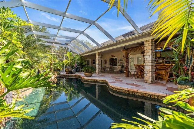 view of swimming pool featuring ceiling fan, a patio area, and a lanai