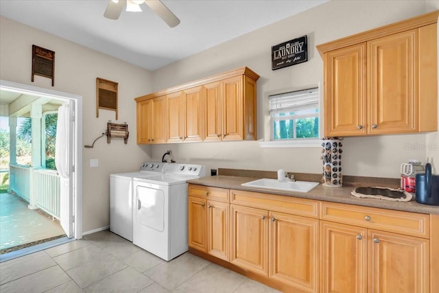 laundry area featuring washing machine and dryer, a wealth of natural light, sink, and cabinets