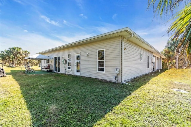 view of side of home featuring a lawn and a patio