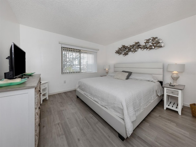 bedroom featuring a textured ceiling and light wood-type flooring