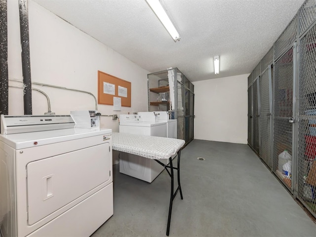 laundry room featuring a textured ceiling and washing machine and dryer