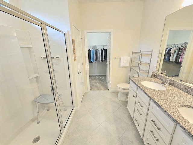 bathroom with toilet, vanity, tile patterned flooring, and a shower with shower door