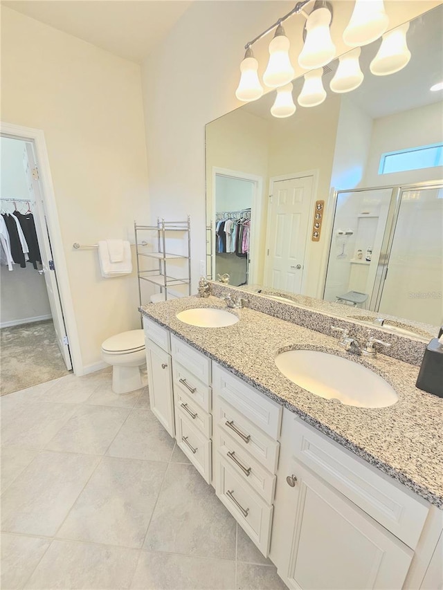 bathroom featuring tile patterned floors, an enclosed shower, vanity, and toilet