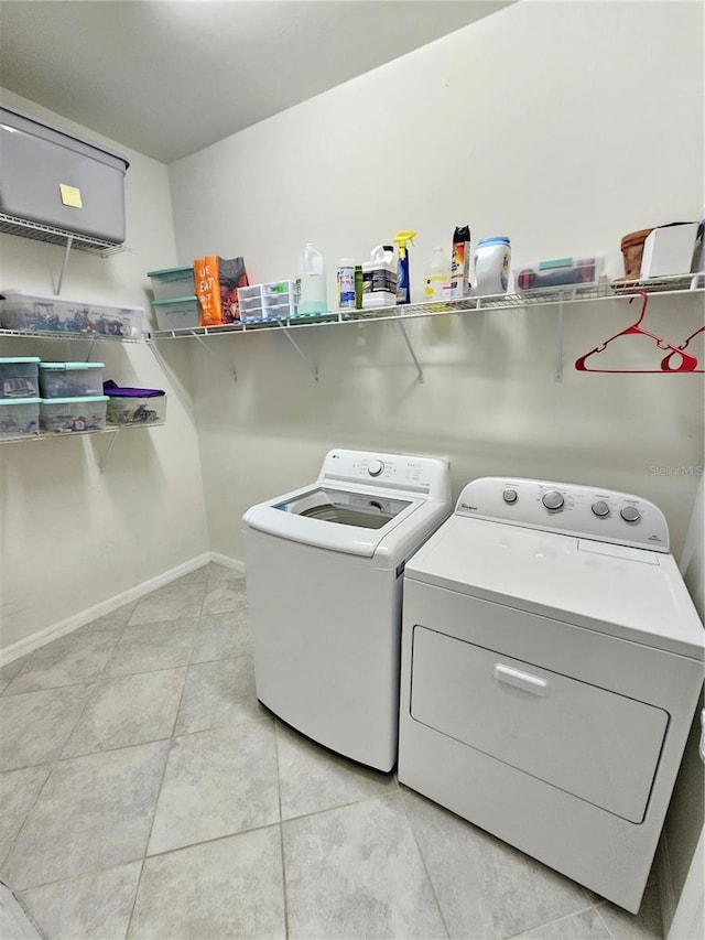 laundry room featuring washing machine and dryer and light tile patterned floors