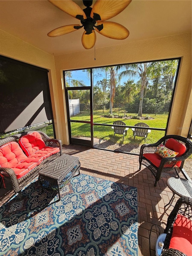 sunroom / solarium featuring ceiling fan