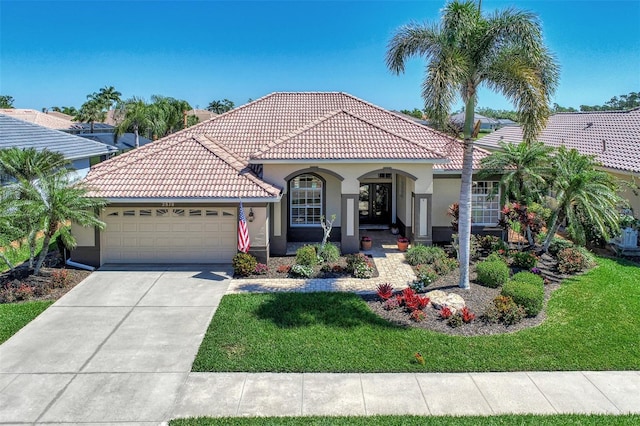 mediterranean / spanish home with a front lawn and a garage