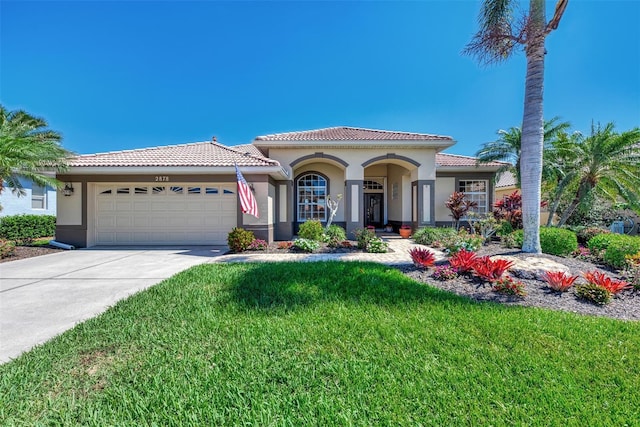 mediterranean / spanish house with a front yard and a garage