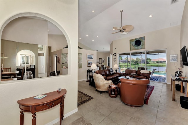 tiled living room with ceiling fan and high vaulted ceiling