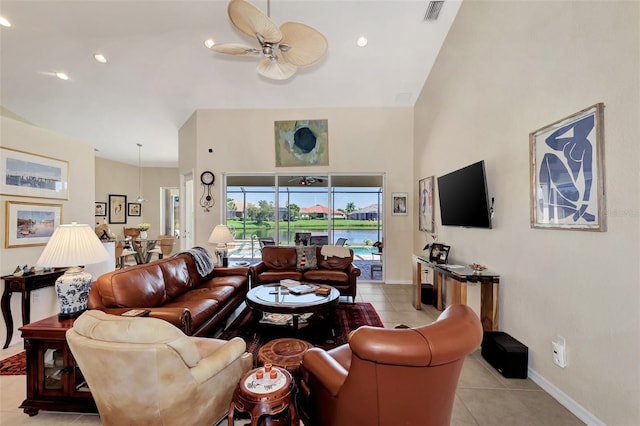 living room with ceiling fan, a towering ceiling, and light tile patterned floors