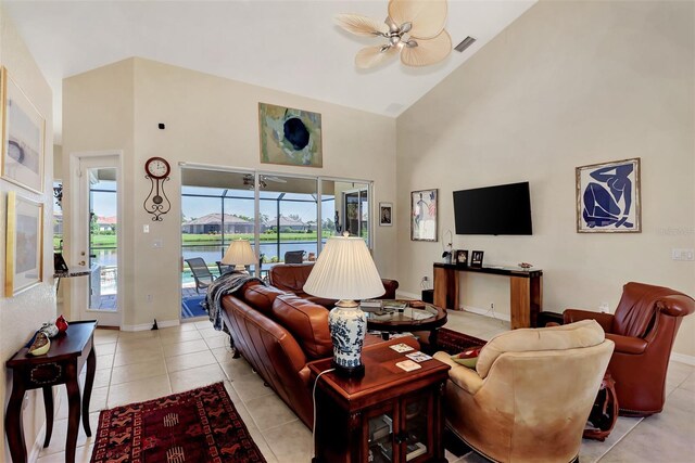 tiled living room with ceiling fan and high vaulted ceiling