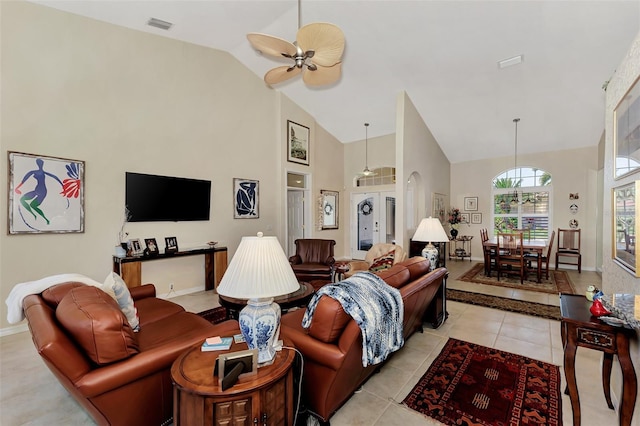 tiled living room featuring ceiling fan and high vaulted ceiling