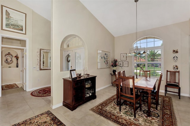 tiled dining room featuring a notable chandelier and high vaulted ceiling