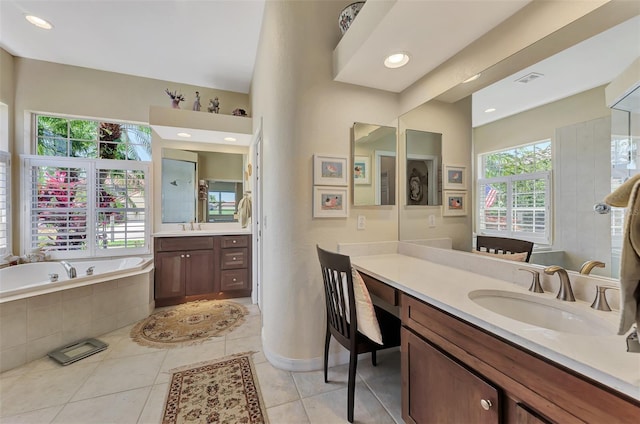 bathroom with tiled tub, tile patterned flooring, and vanity