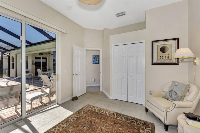 living area with ceiling fan and light tile patterned floors