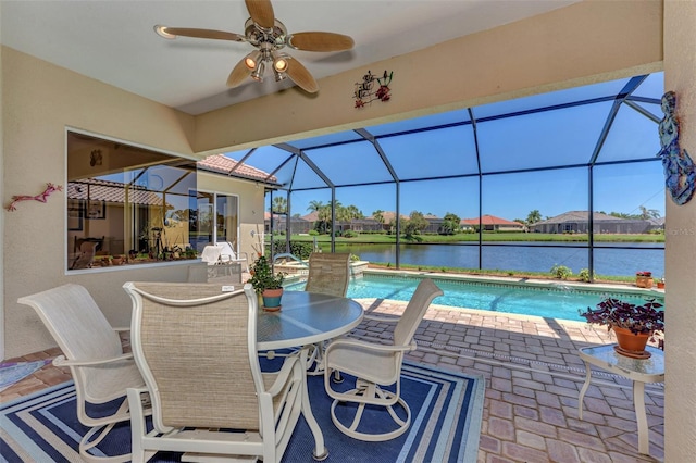 view of swimming pool featuring glass enclosure, ceiling fan, and a water view