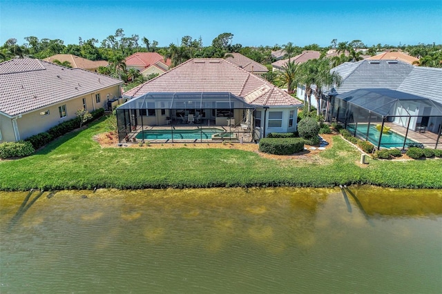 back of property with a lawn, glass enclosure, and a water view