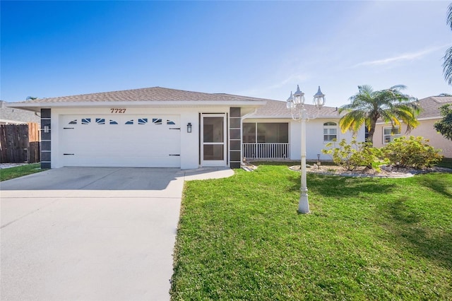 single story home featuring a front yard, a garage, and a sunroom