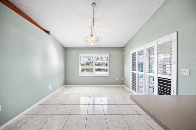 unfurnished dining area featuring a textured ceiling, light tile patterned floors, vaulted ceiling, and an inviting chandelier