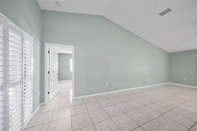 spare room with lofted ceiling and light tile patterned floors