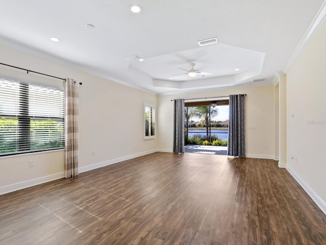 spare room with ceiling fan, a raised ceiling, crown molding, and wood-type flooring