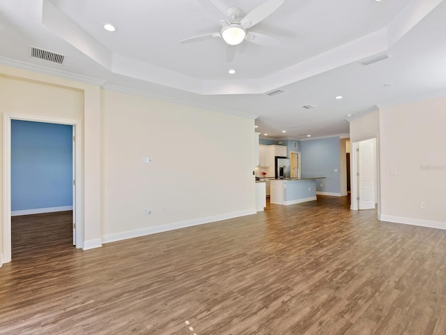 unfurnished living room with light hardwood / wood-style floors, crown molding, a raised ceiling, and ceiling fan